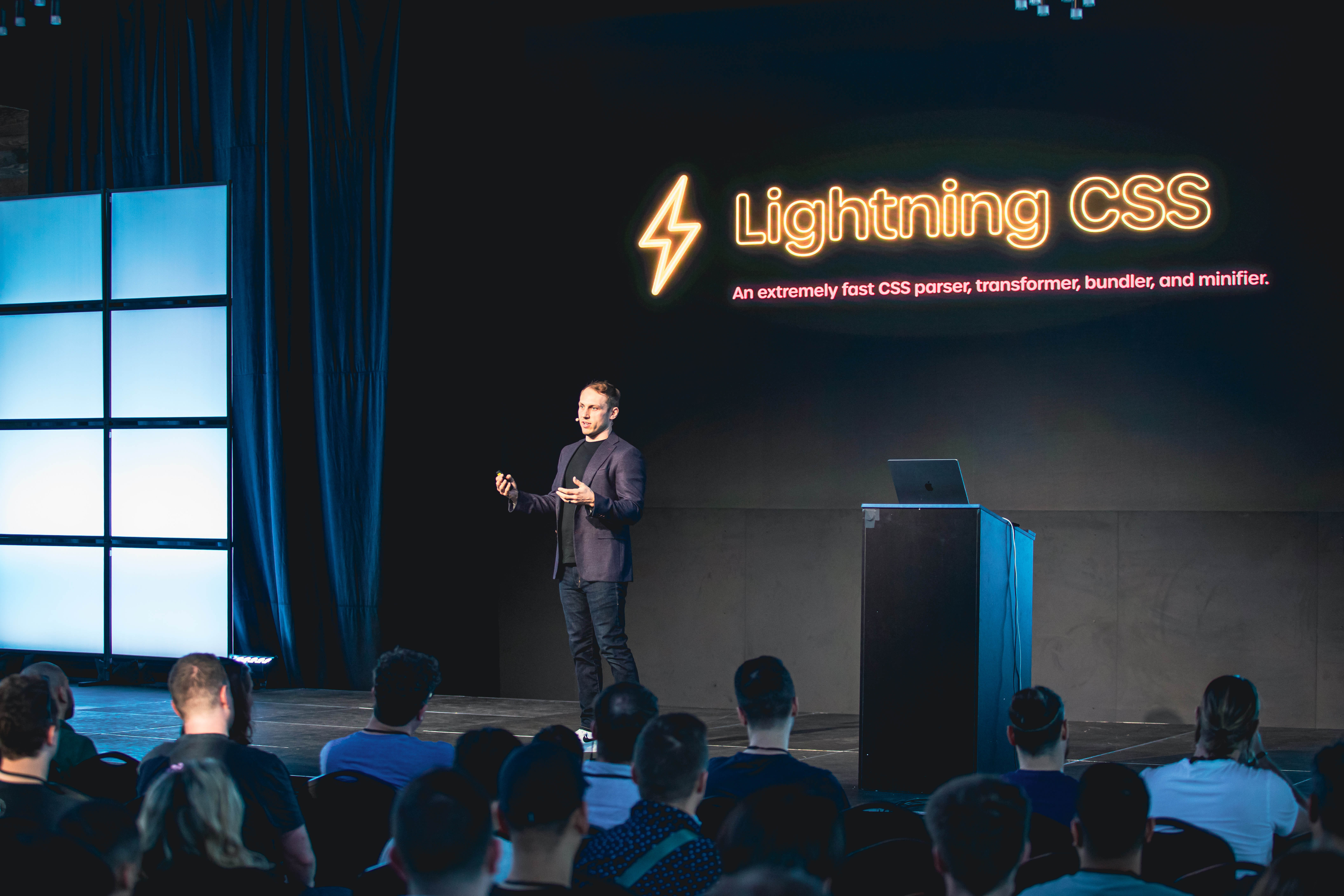 Adam Wathan on stage in front of a slide that says Lightning CSS